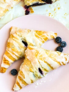 Blueberry Turnovers on a pink plate with fresh blueberries