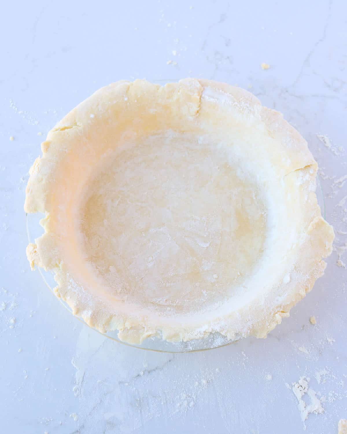 Unbaked pie dough placed in a pie dish.