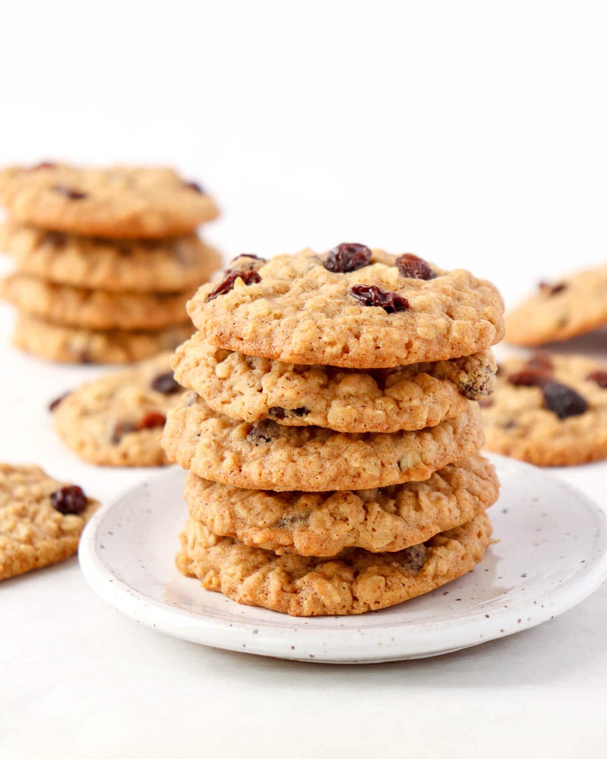 Stack of oatmeal raisin cookies on a white plate.