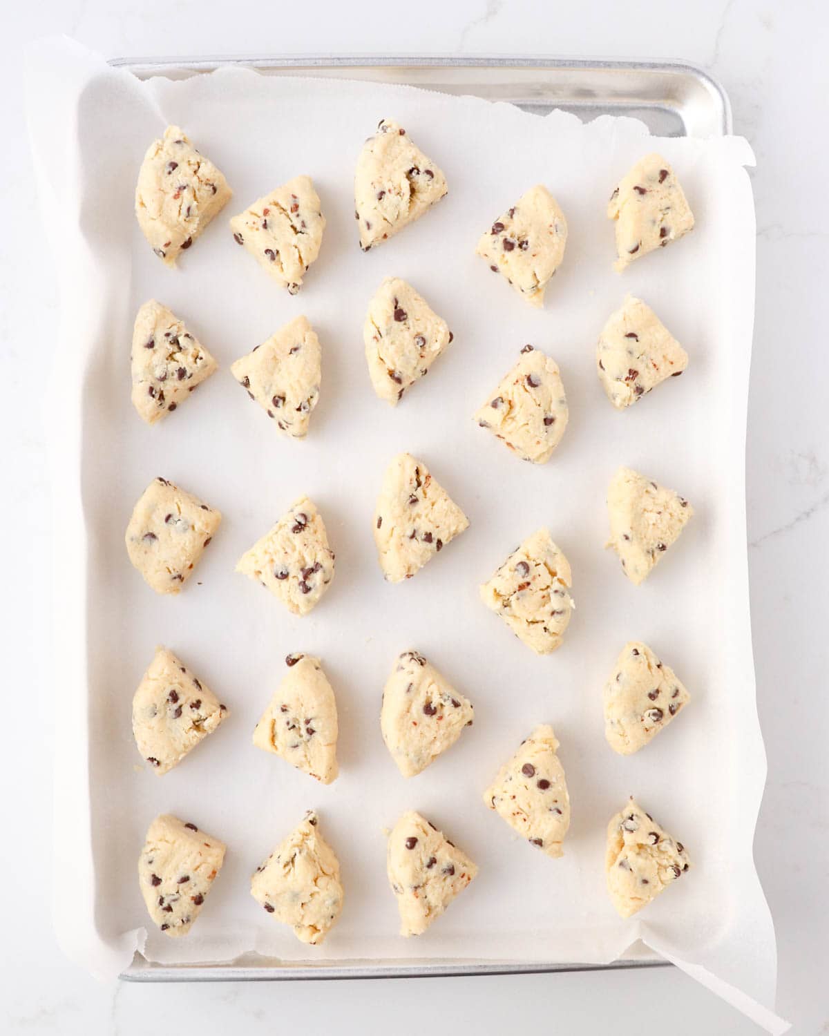 24 unbaked mini scones on a baking sheet lined with parchment paper.