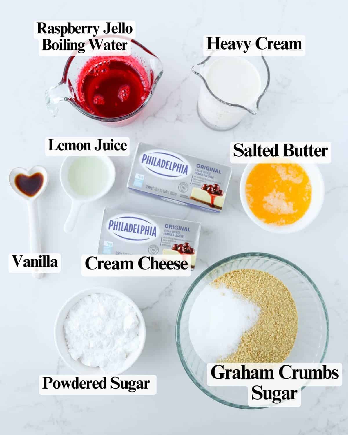 Labeled ingredients for the cheesecake in bowls on a countertop.