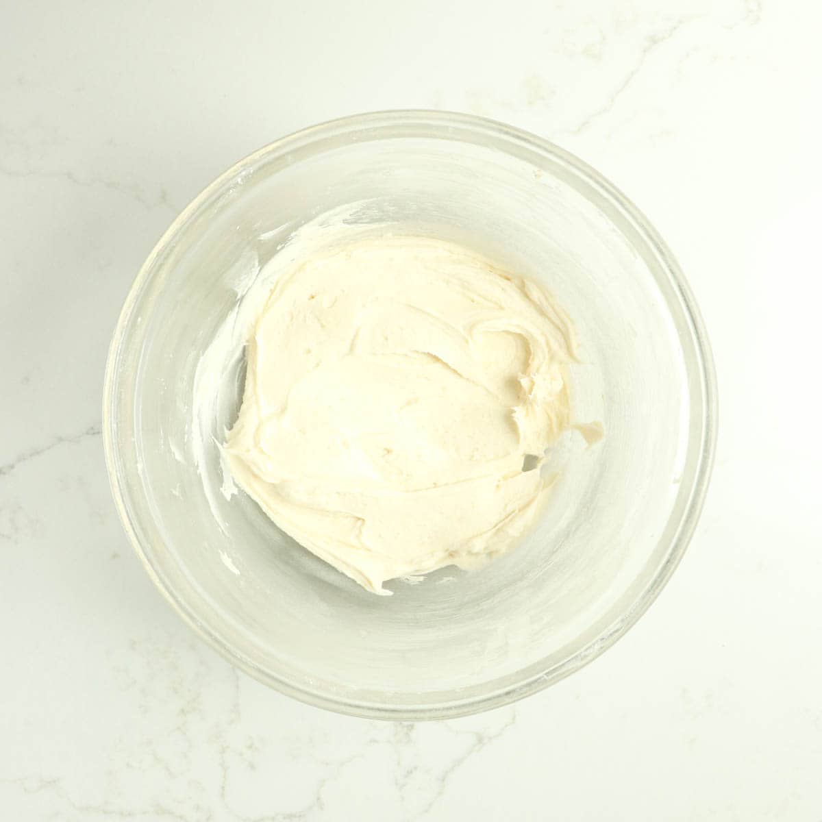 Cream cheese frosting filling in a glass bowl.