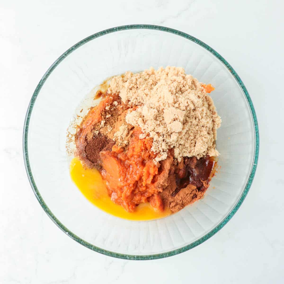 Pumpkin filling ingredients in a glass mixing bowl.