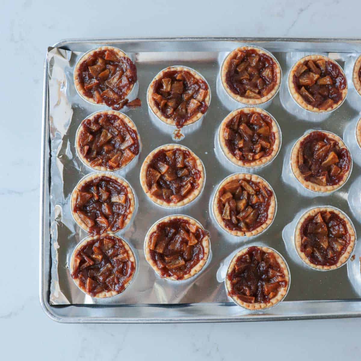 Baked tarts on a baking pan.