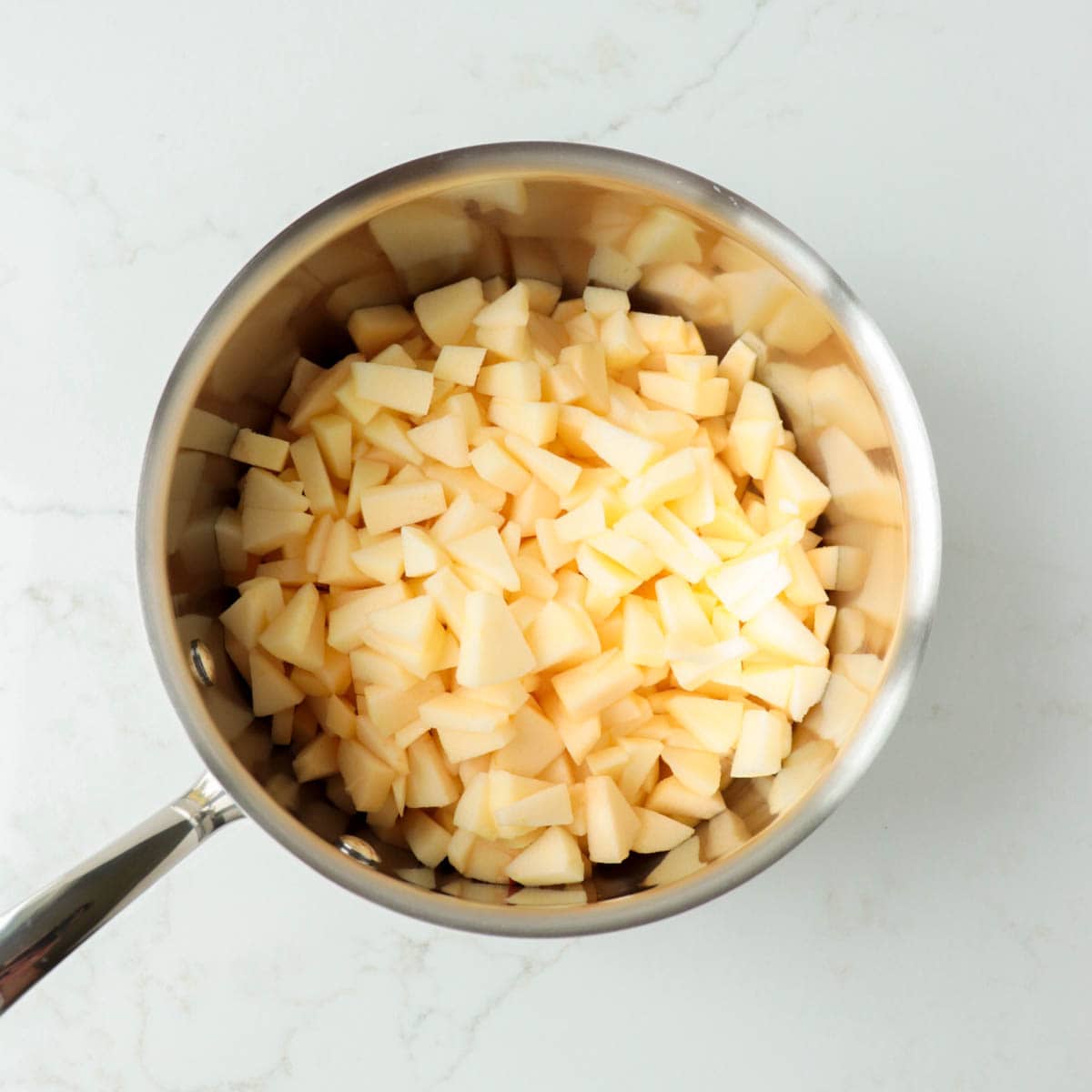 Chopped apples in a metal pot.