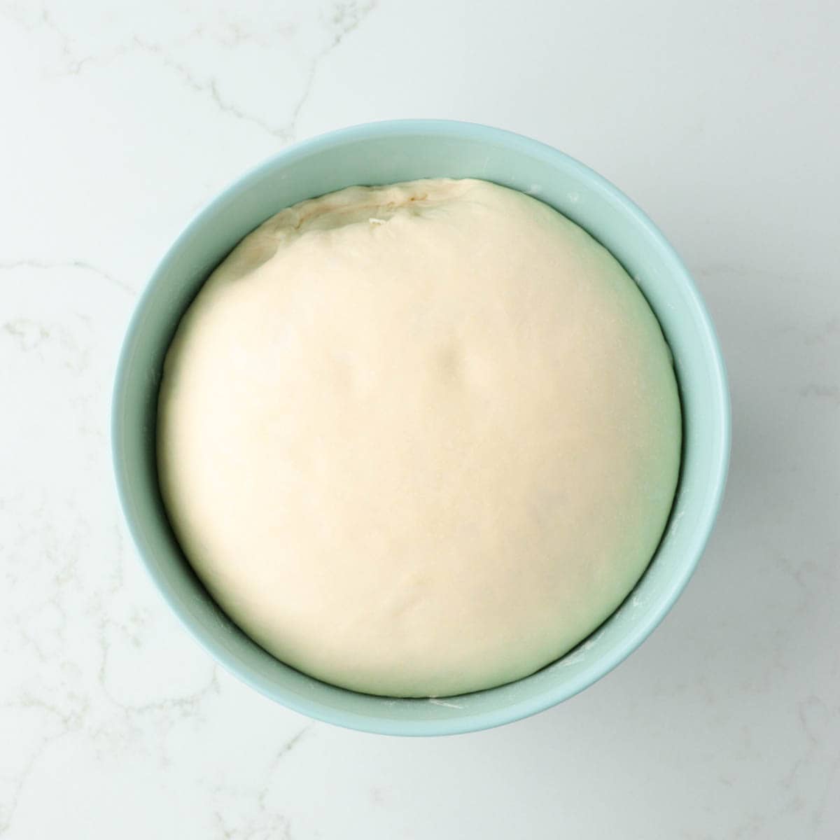 Dough in bowl doubled in size after rising.