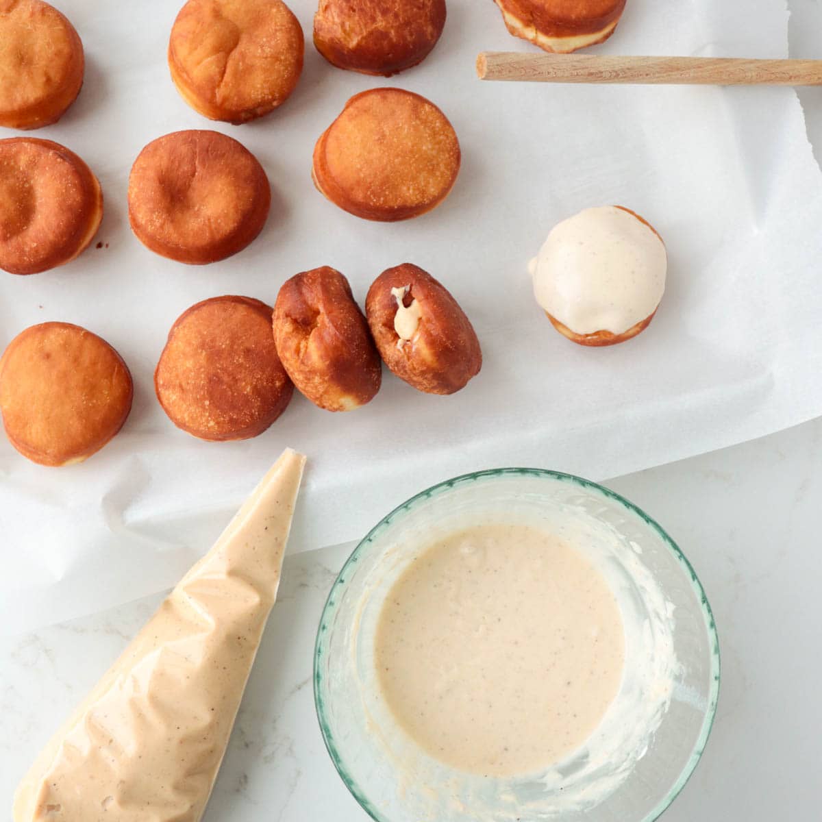 Filling doughnuts with custard and topping with icing.