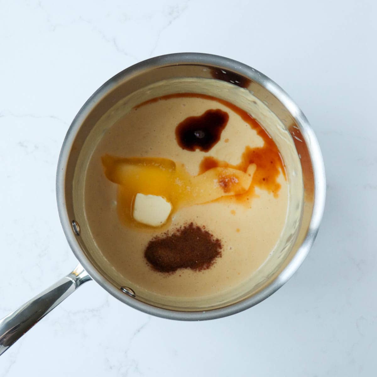 Ingredients added to cooked custard mixture in a metal saucepan.