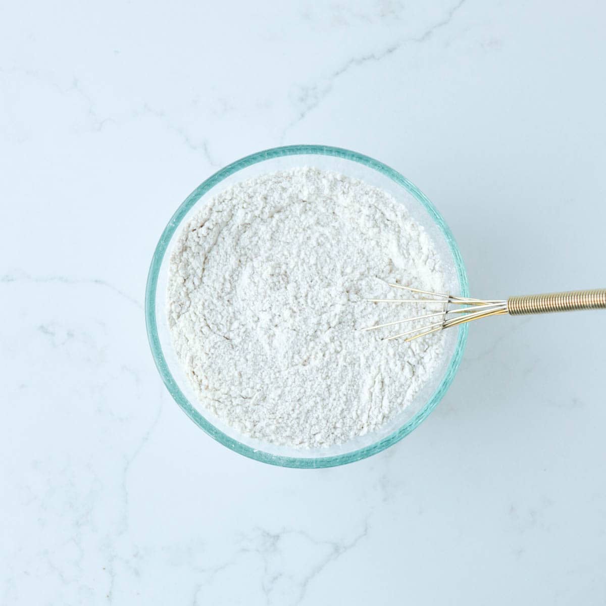 Dry ingredients combined in a glass bowl.