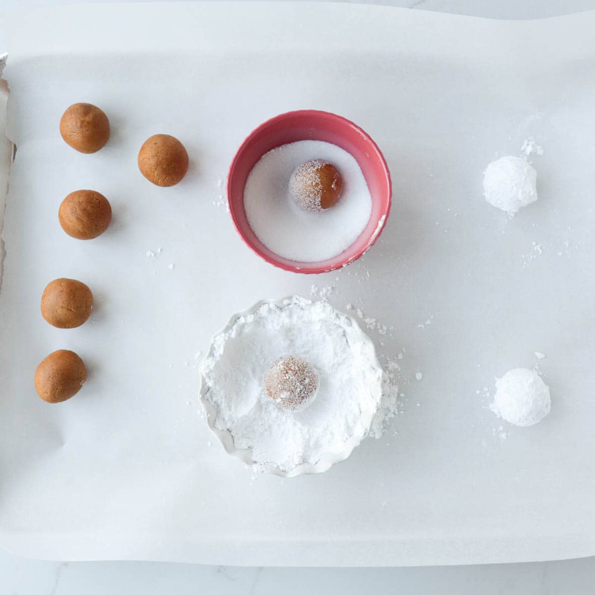 Rolling cookie dough balls in sugar.