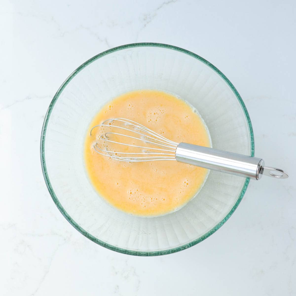 Ingredients whisked together in a glass mixing bowl.