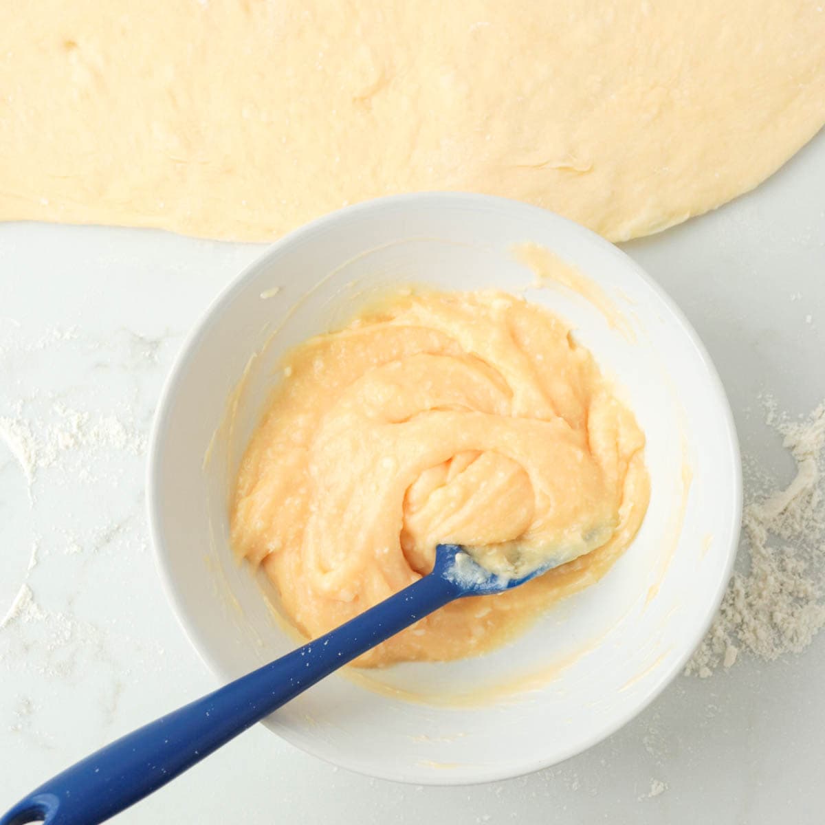 Lemon curd and butter combined in a bowl.