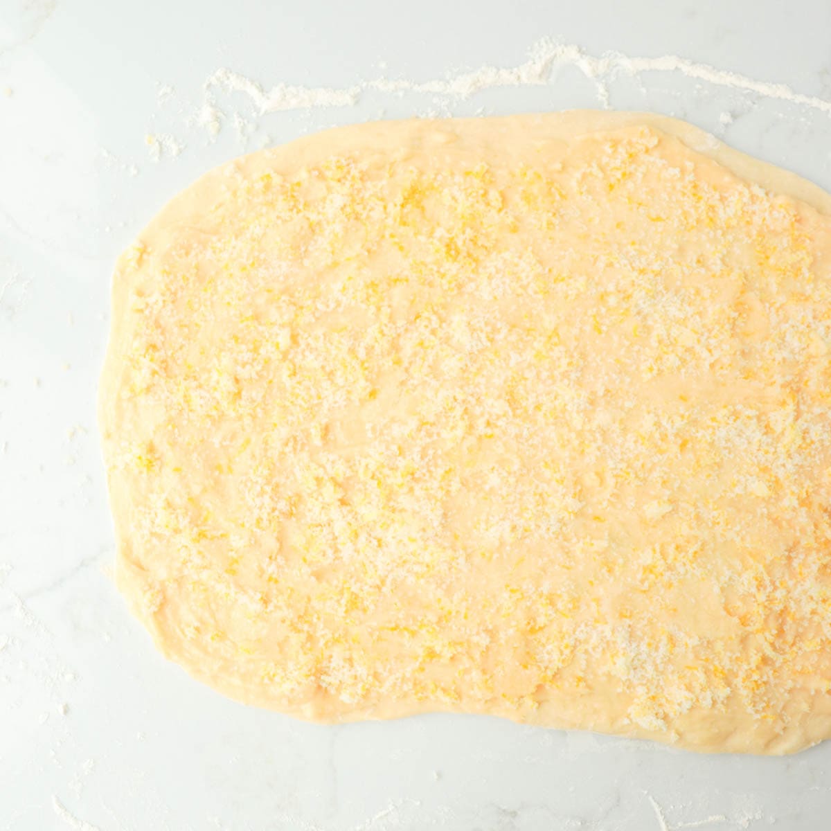 Dough rolled out with lemon filling spread around on top.