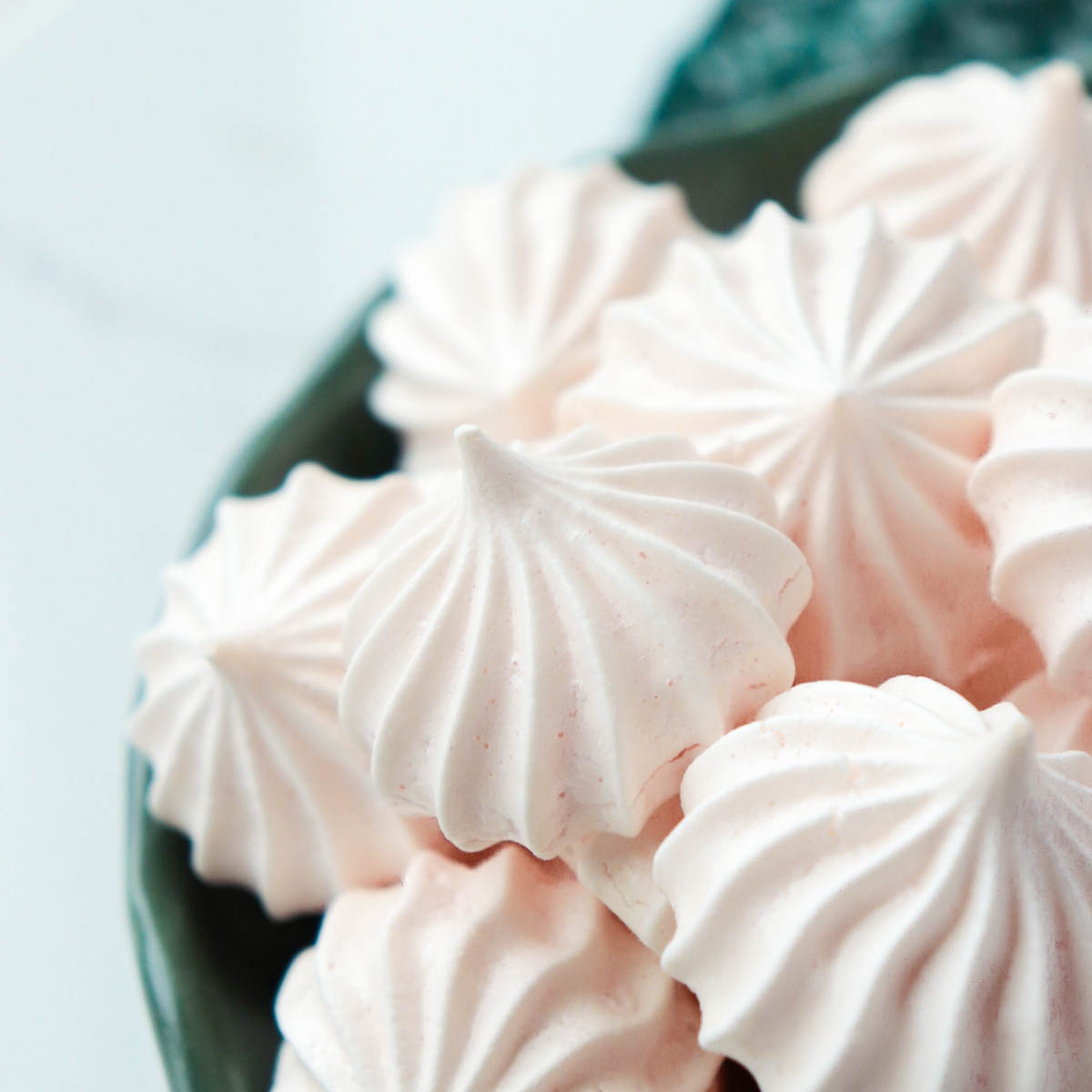 Meringues in a dark green dish.