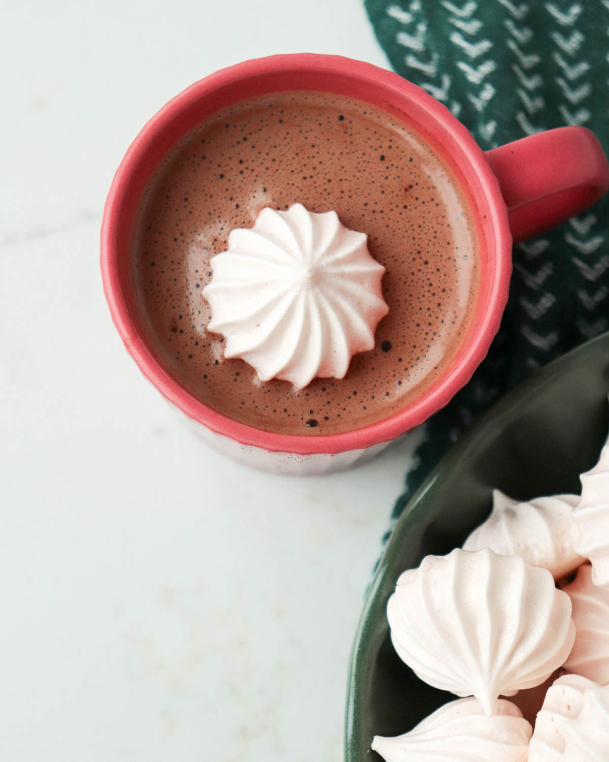 Vanilla peppermint meringue on top of hot chocolate in a pink mug.