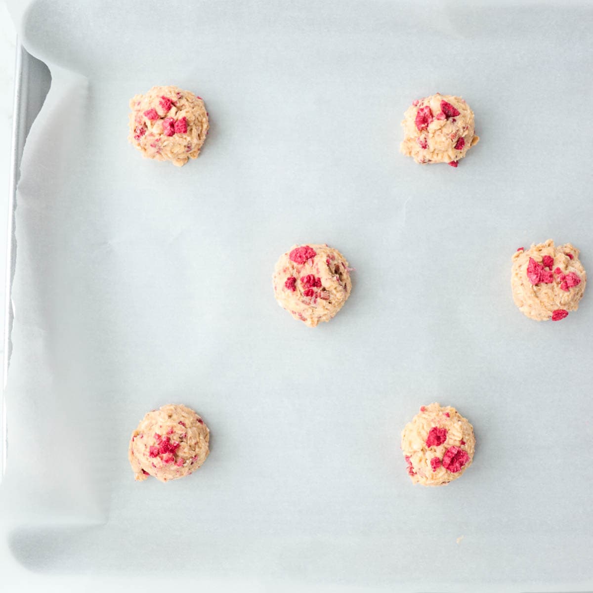 Cookie dough on a baking pan before baking.