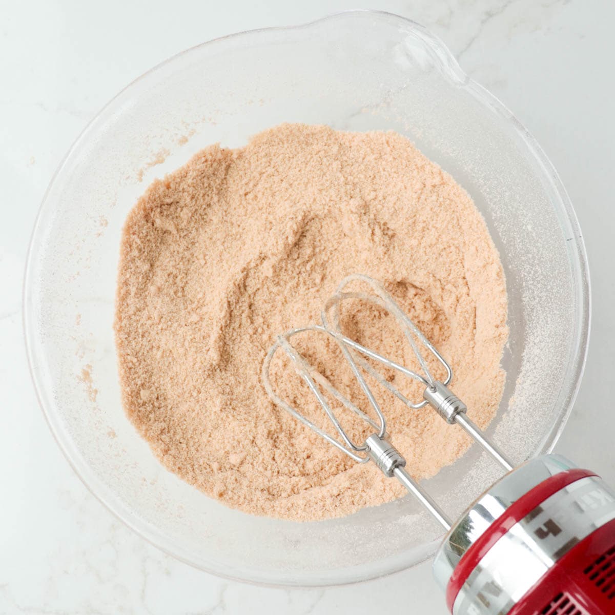 Butter, brown sugar, and dry ingredients mixed together in a glass bowl.