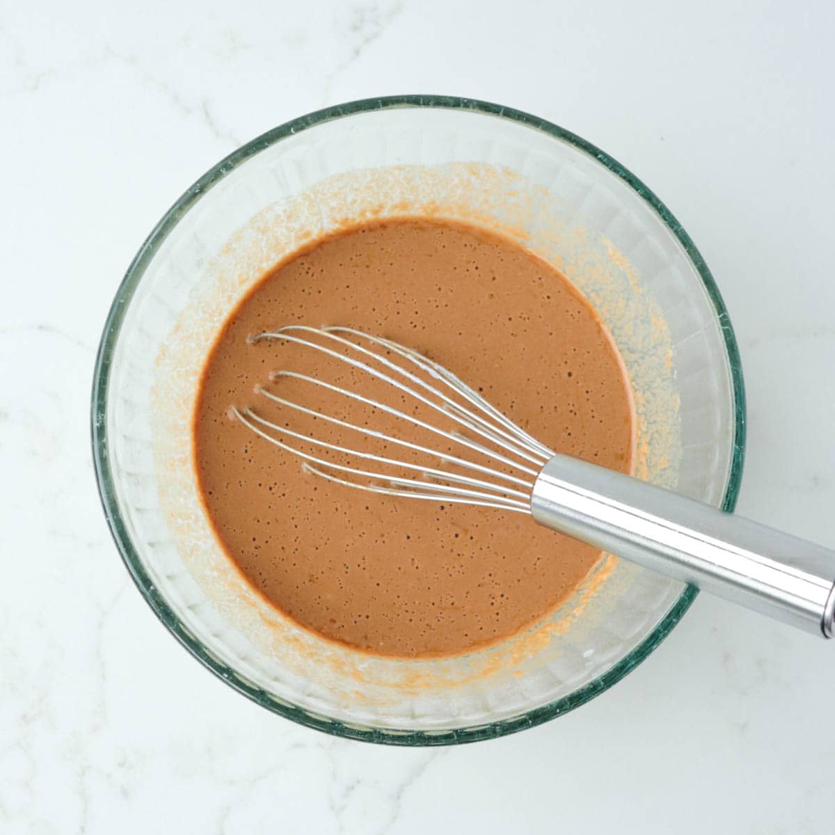 Wet ingredients whisked together in a mixing bowl.