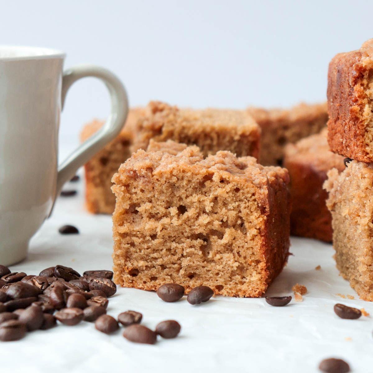 Piece of coffee cake next to a cup of coffee.