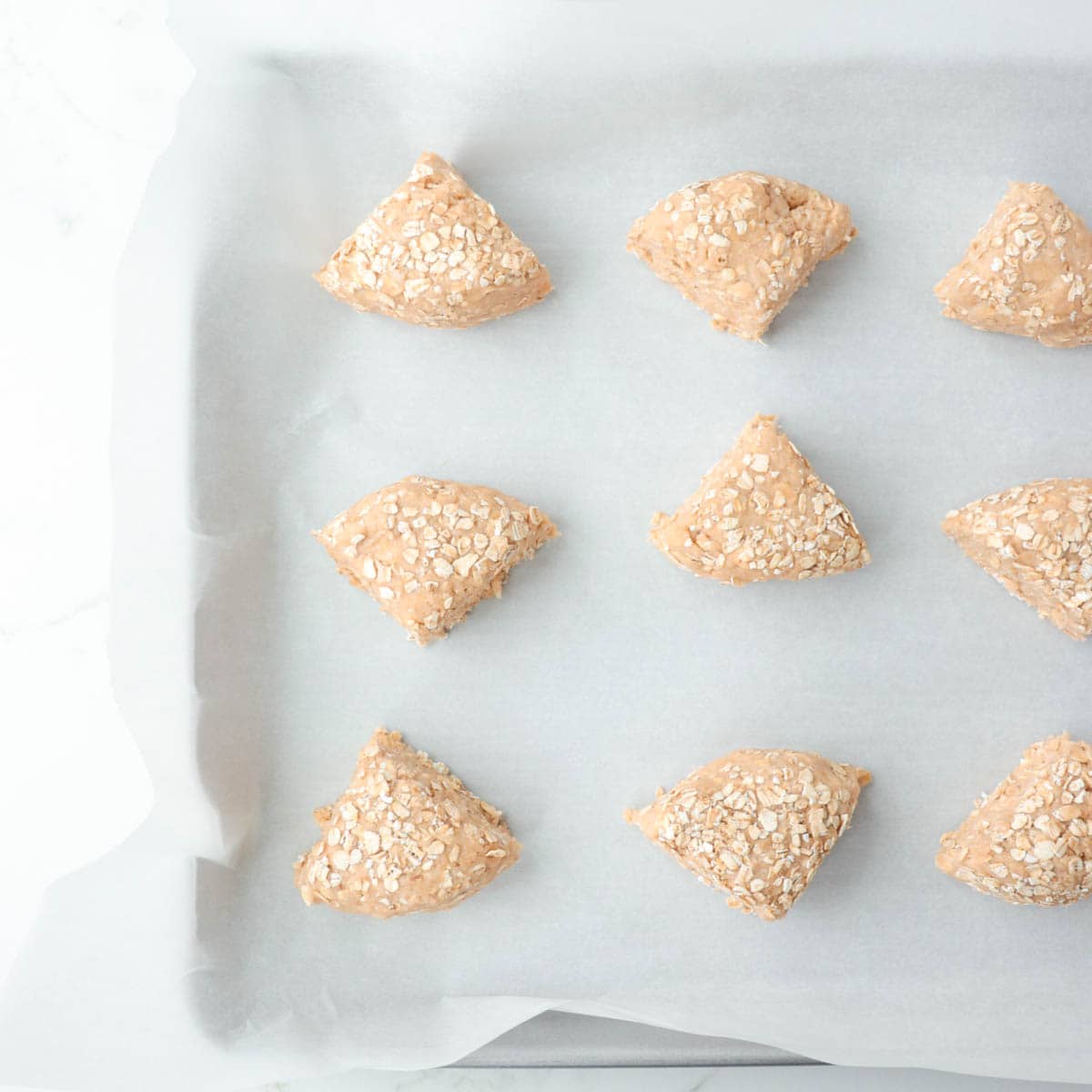 Scones on a baking sheet lined with parchment paper.