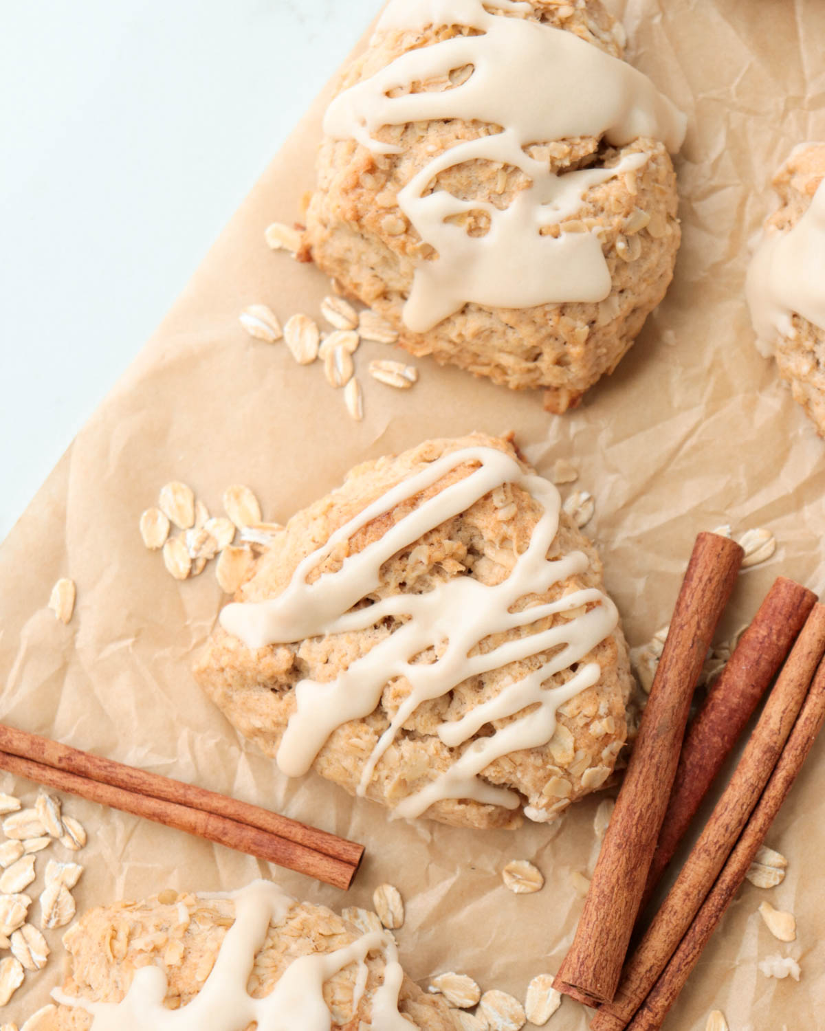 Scones on a piece of parchment paper with cinnamon sticks.
