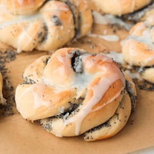Poppy seed bun topped with drizzle of white icing.