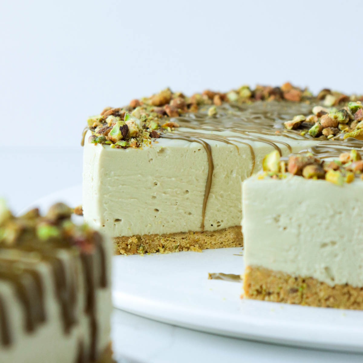 Pistachio cheesecake on a white plate.
