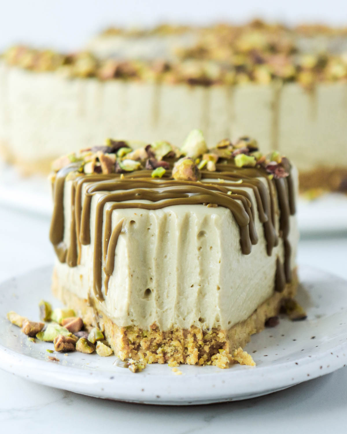 Slice of pistachio cheesecake with forkful taken.