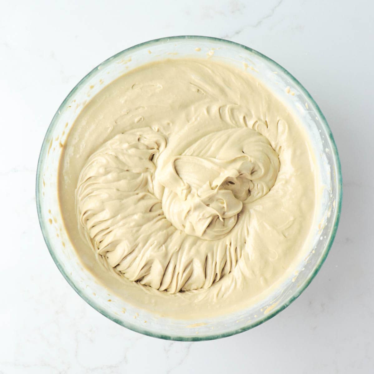 Whipped pistachio cheesecake batter in a bowl.