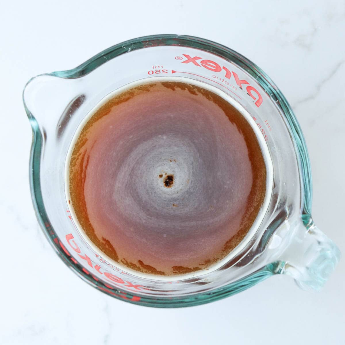 Instant coffee granules dissolved in water.