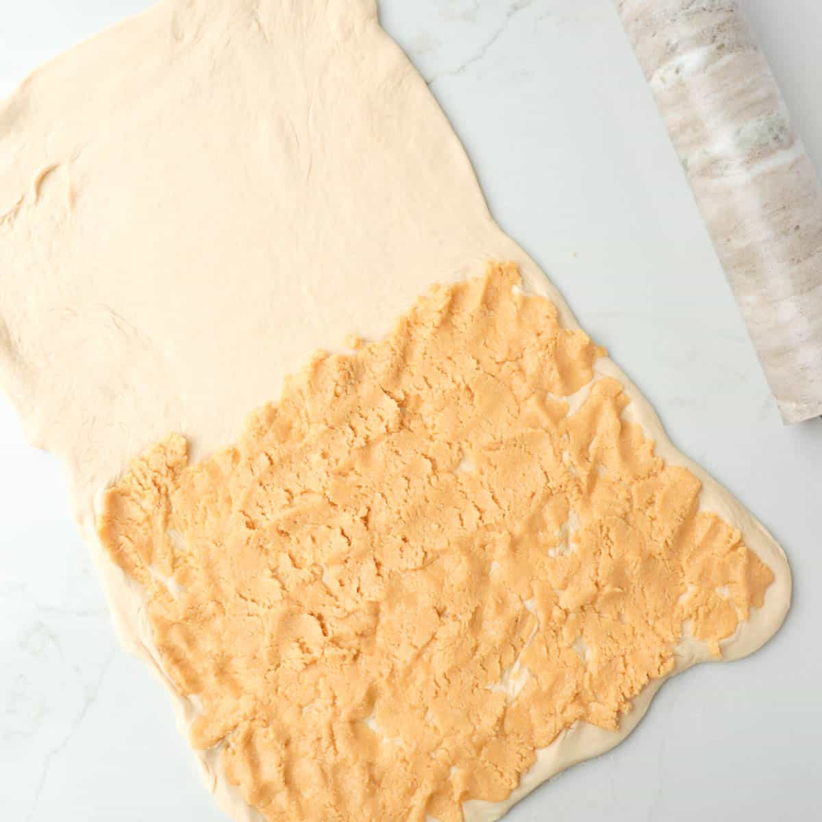 Almond paste spread onto half of the dough that has been rolled out into a rectangle.